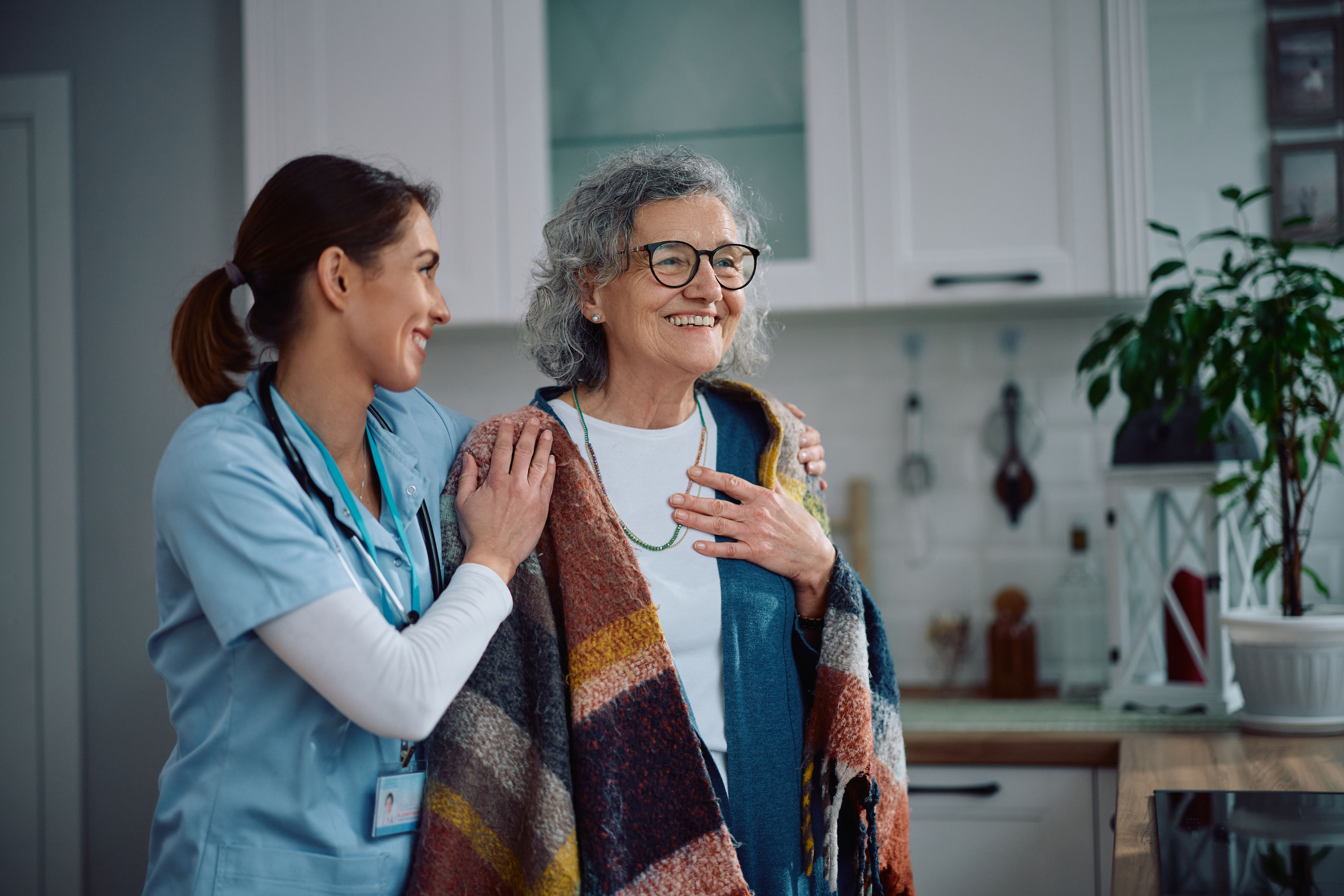 Elderly lady with her carer, standing in the kitchen